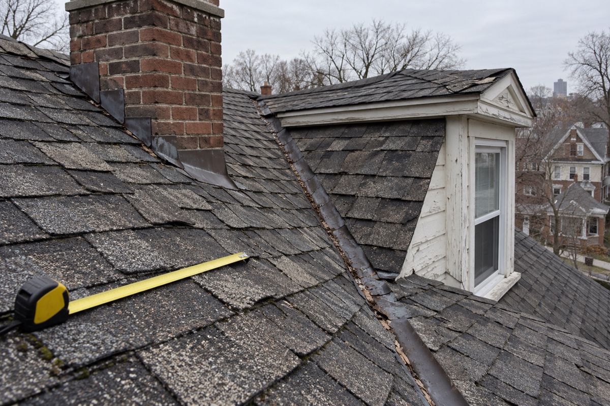Steep older shingle roof with chimney, dormer and valley that raise price